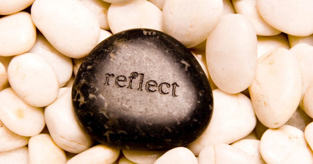 A stone with the word reflect on it